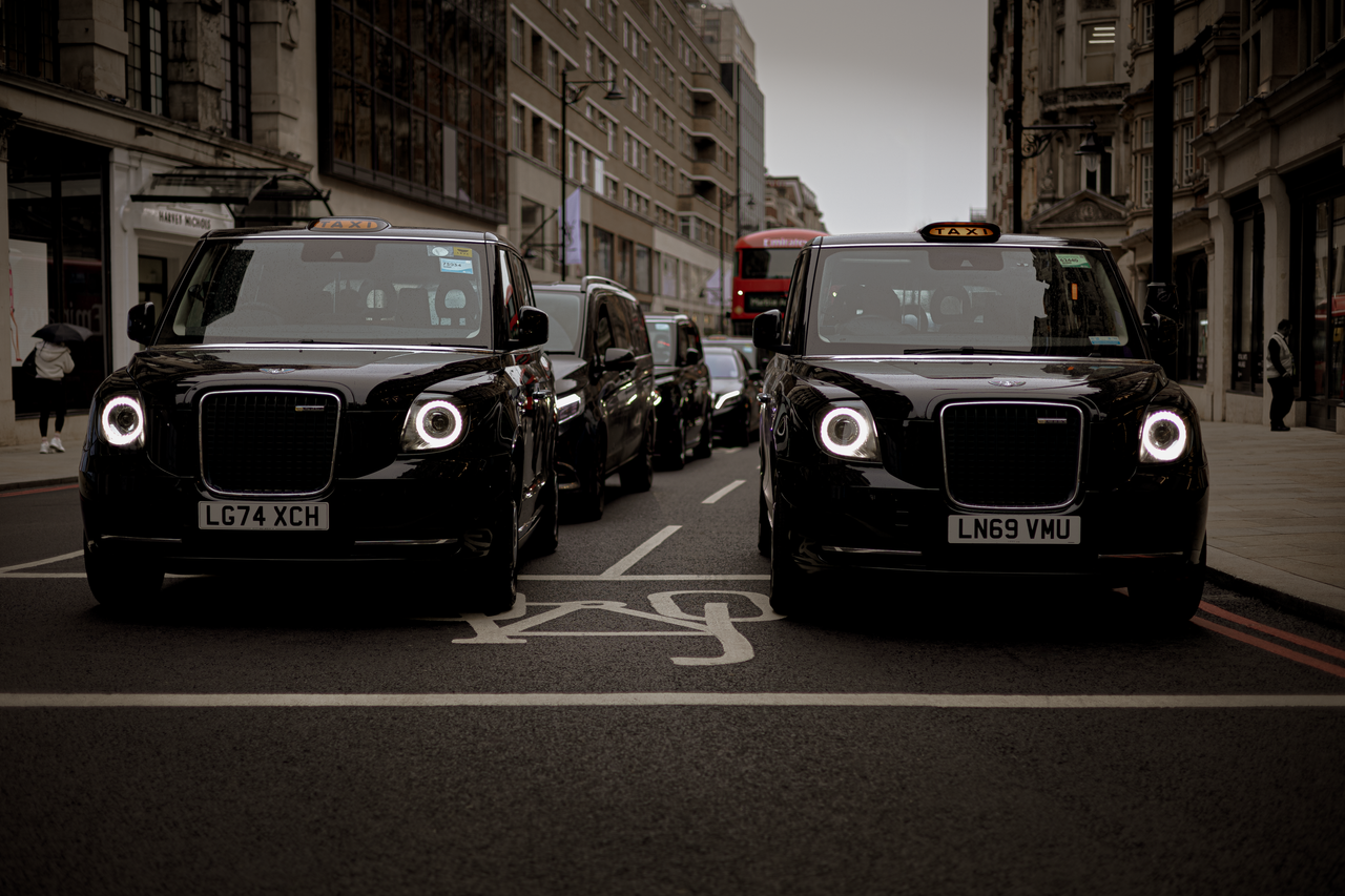 Contact Black taxis line up on a London street showcasing modern urban transportation.
