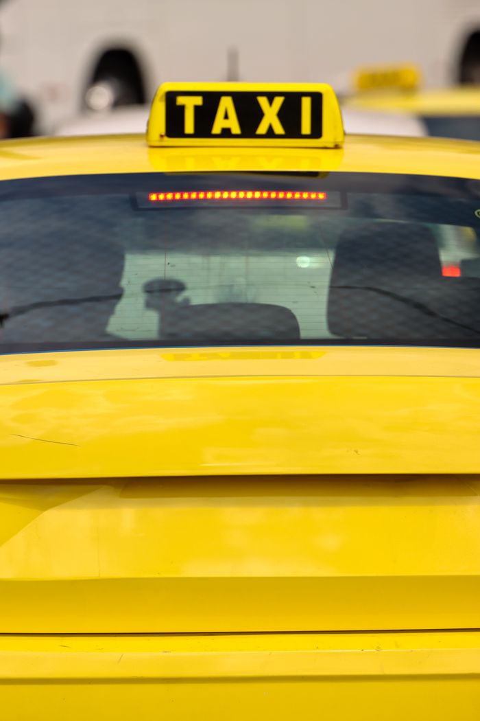 About Close-up of a yellow taxi in Athens, Greece, highlighting the bright sign and urban setting.