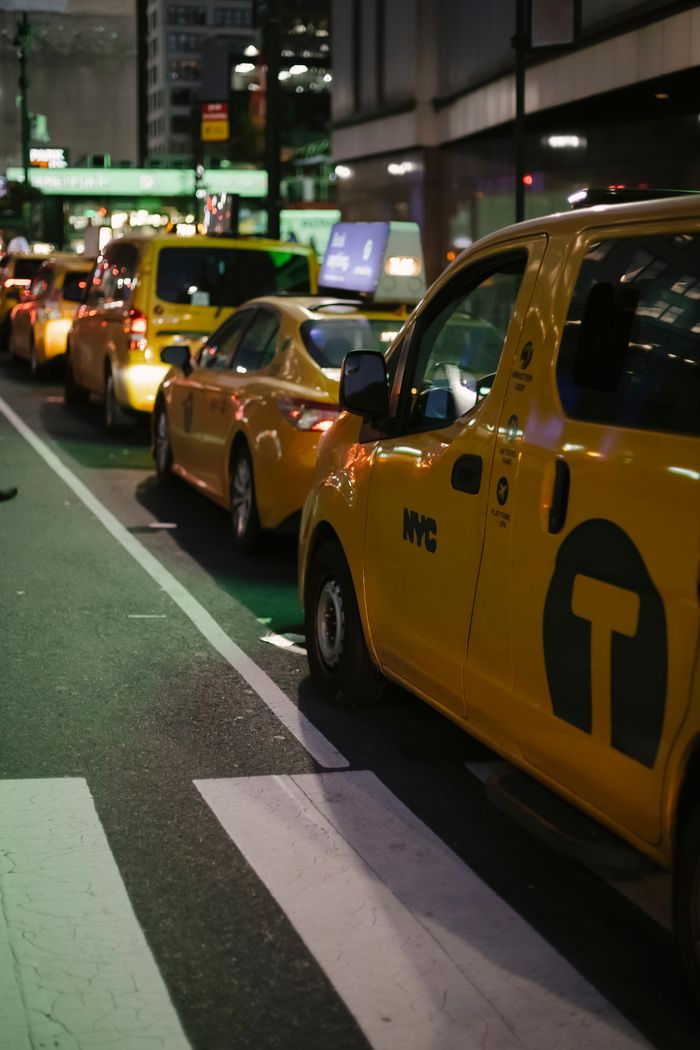 Crafting Captivating Headlines: Your awesome post title goes here Row of modern various yellow taxi vehicles parked on city street near buildings in New York at night